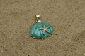 Pendant with turquoise stone and starfish design on a gray background
