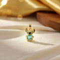 14K STITCH HOLDING A BLUE HEART-SHAPED STONE